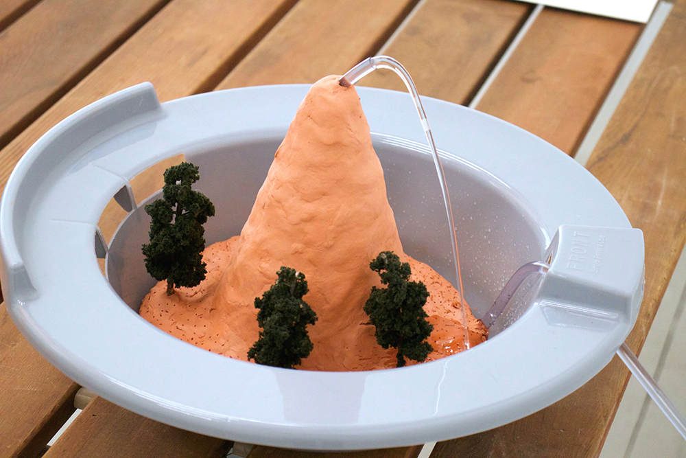 Water squirting out of a mound of clay in a sitz bath
